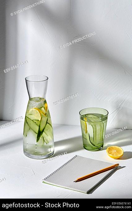 water with lemon and cucumber and notebook