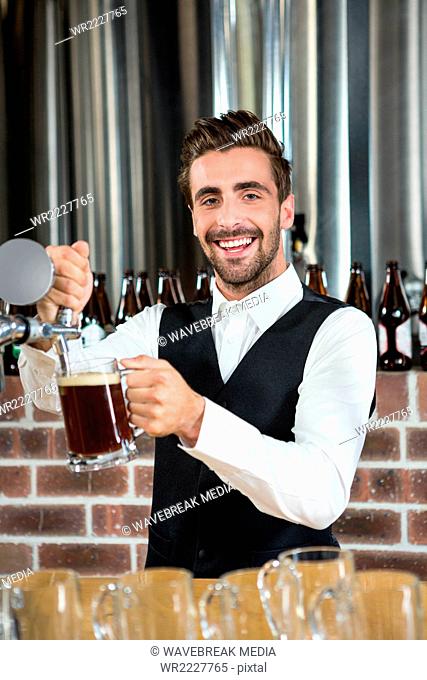 Barman pouring beer