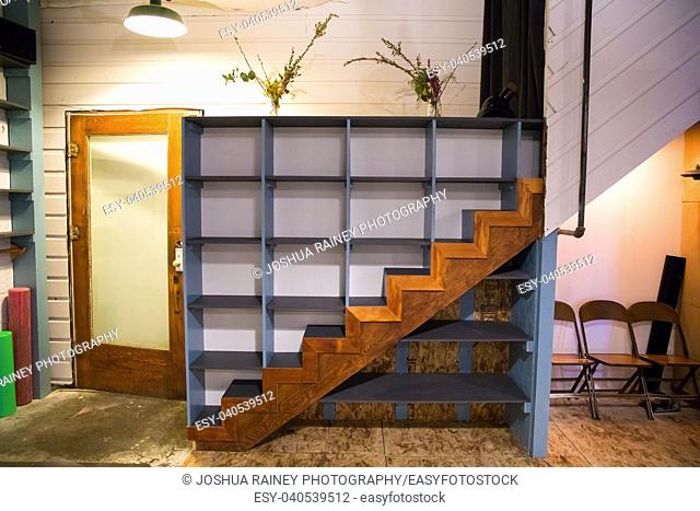 Cubbies built onto a staircase create a spot for students to put their things while practicing yoga at an urban studio