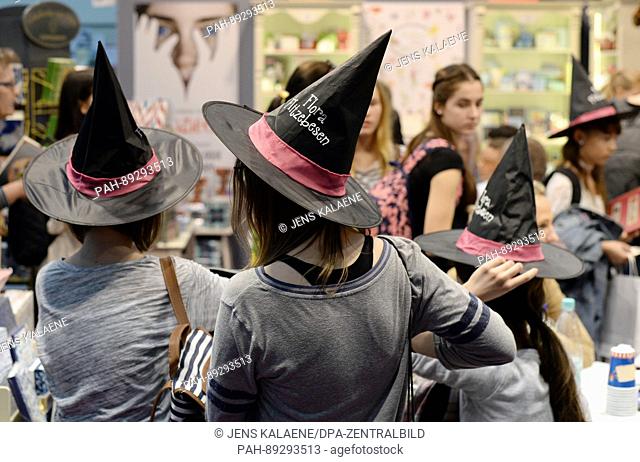 Children and teenagers, some of whom are wearing hats, seen at a booth featuring children's literature at the book fair in Leipzig, Germany, 23 March 2017