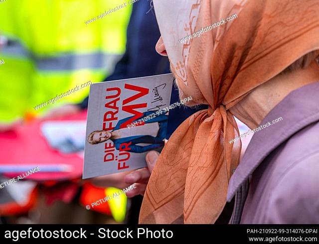 22 September 2021, Mecklenburg-Western Pomerania, Hagenow: An elderly woman wearing a headscarf holds a signed autograph card of the Prime Minister of...