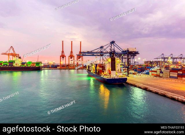 Container ships at illuminated dock