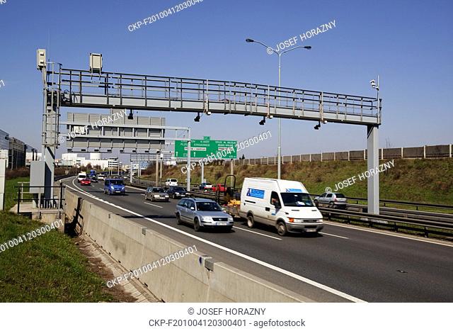 ***FILE PHOTO*** Cars and trucks drive beneath a toll bridge of the Czech highway toll system is seen on a highway near Prague, Czech Republic on Apr