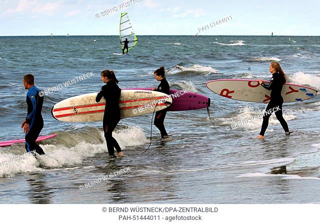 Participants of a surfing course surf on the waves in the first attempt in Rostock-Warnemuende,  Germany, 21 August 2014