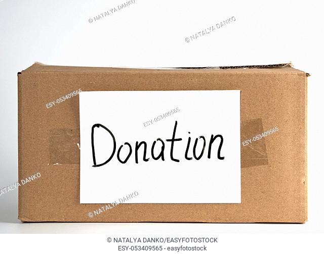 closed brown cardboard box with the inscription donation , white background