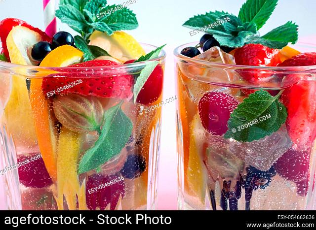 Summer refreshing cocktail of natural fruits and various berries with ice and mint leaves infused with water. Contains lemon, orange, strawberry, cherry