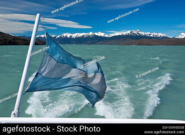 Argentinian flag waving in the wind, on a boat on the Lake Argentino in Patagonia