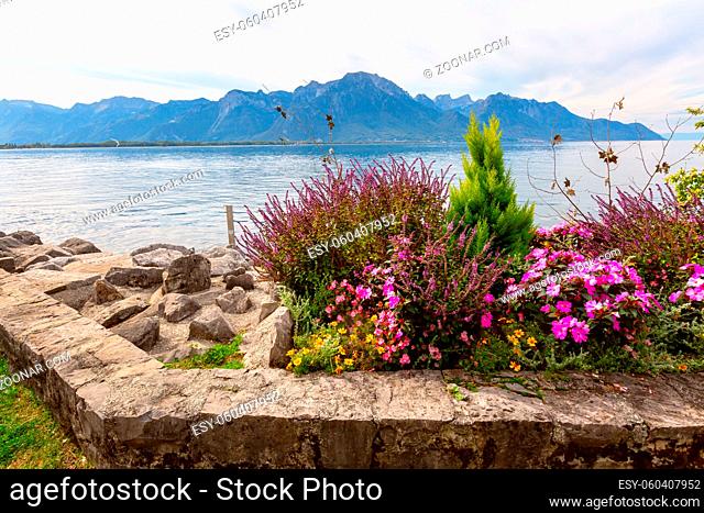 Panoramic view of Lake Geneva, Switzerland from Montreux promenade with colorful flowers and trees