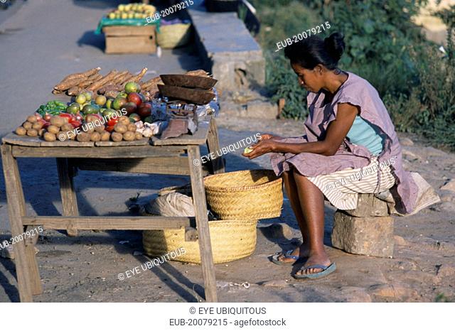Woman selling fruit and vegetables on a roadside stall