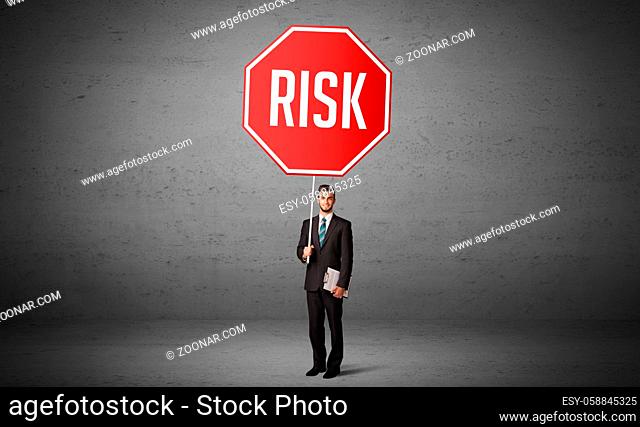 Young business person holding road sign with RISK inscription, new rules concept