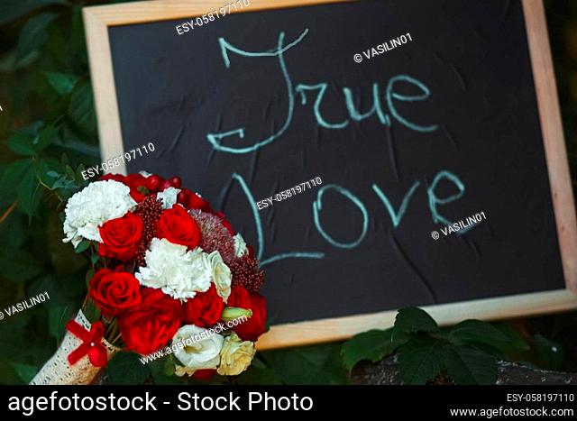 The inscription is true love on a black background framed. A bouquet of flowers