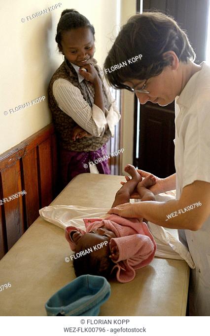 Madagascar, Fianarantsoa, Doctor examining baby for a mother and child group