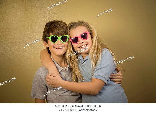 Brother and sister wearing heart-shaped sunglasses