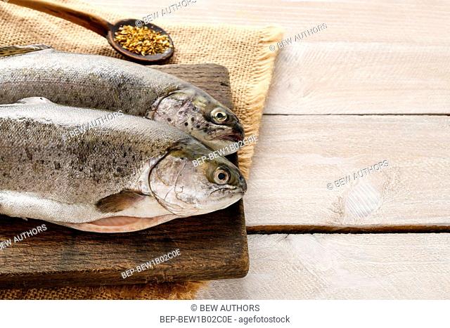 Two rainbow trouts on rustic wooden table, copy space