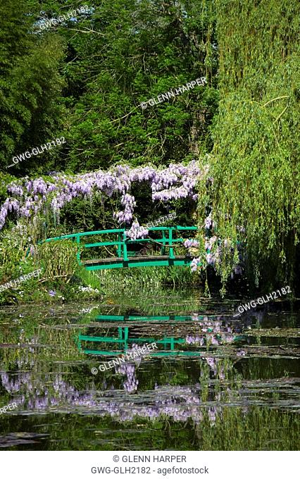 BRIDGE AND WISTERIA REFLECTED IN POND AT MONET'S GARDEN GIVERNY FRANCE
