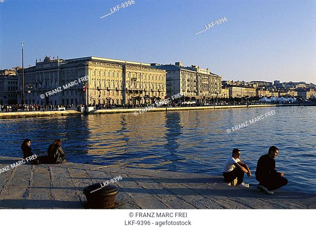 People sitting on the pier in the evening sun, Mola Audace, Trieste, Friuli, Italy, Europe