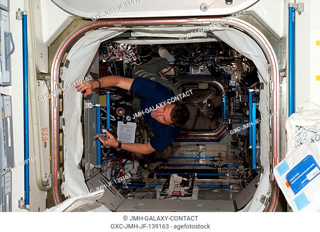 NASA astronaut Reid Wiseman, Expedition 40 flight engineer, floats through the hatch between the Destiny laboratory and the Unity node of the International...