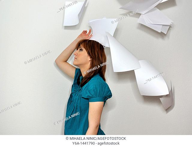 Young woman throwing paperwork in air