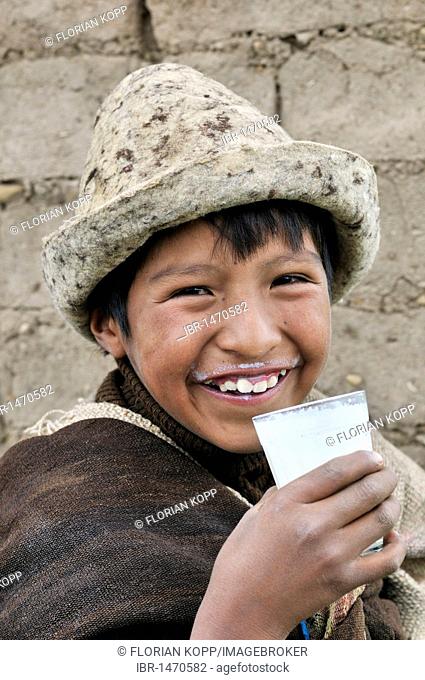 Shepherd boy, traditional dress, with a glass of milk, Bolivian Altiplano highlands, Departamento Oruro, Bolivia, South America