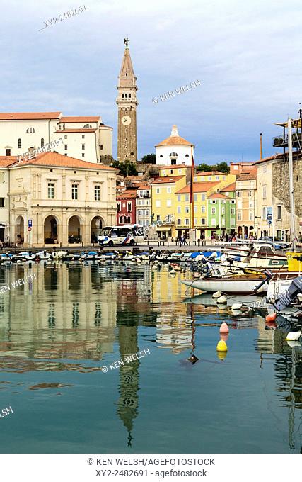 Piran, Primorska, Slovenia. View across harbour to Tartinijev trg (or square) and the spire of St. George's cathedral