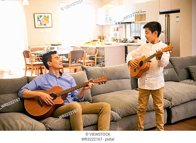 Father and his son in playing the guitar
