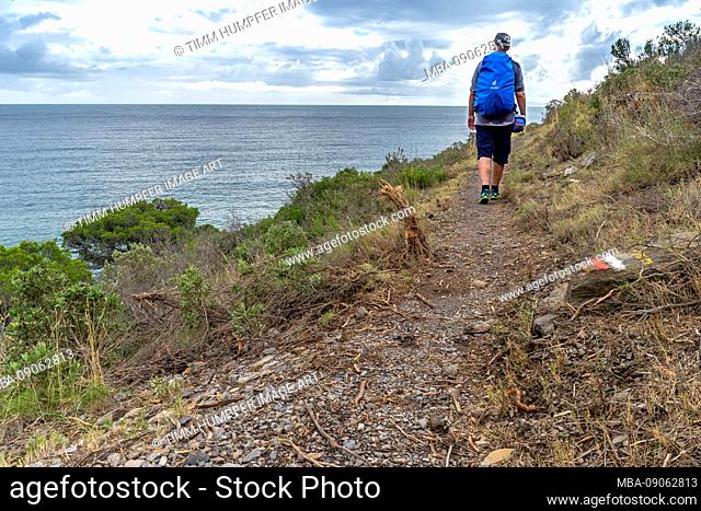 Europe, Spain, Catalonia, Costa Brava, hiker enjoys the view over the Mediterranean Sea near the bay of Badia de Montjoi