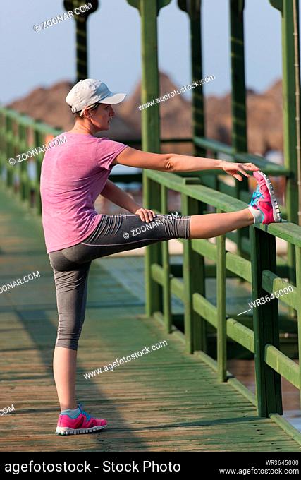 runner  woman warming up and stretching before morning jogging