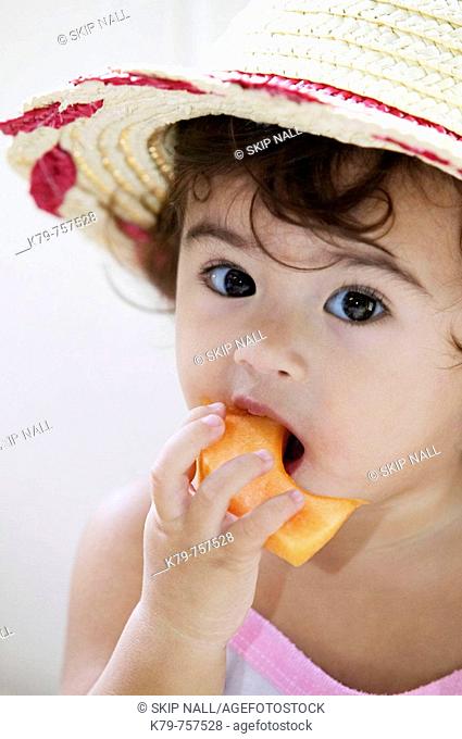 Little girl eating fruit