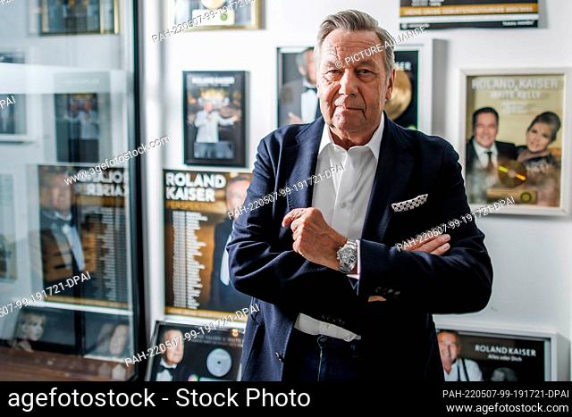PRODUCTION - 28 April 2022, Berlin: Roland Kaiser, pop singer, stands in front of a wall of posters and golden records for his music at the concert agency...
