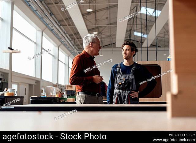 Businessman having discussion with colleague in workshop