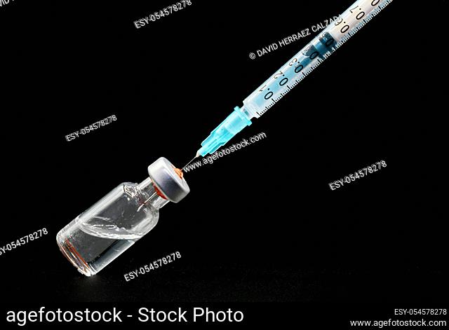 Close up, preparing the syringe and vial, for vaccination, on black isolated background