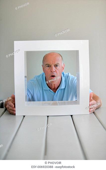 A surprised elderly man framed by a square