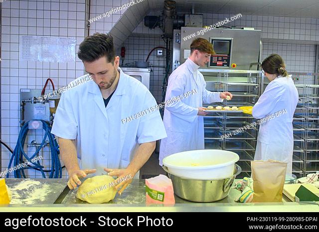 19 January 2023, Saxony-Anhalt, Bernburg: Ecotrophology students Timon-Joel Strauch (l-r), Finn Spielmann and Hannah Raudszus bake legume bread rolls in the...