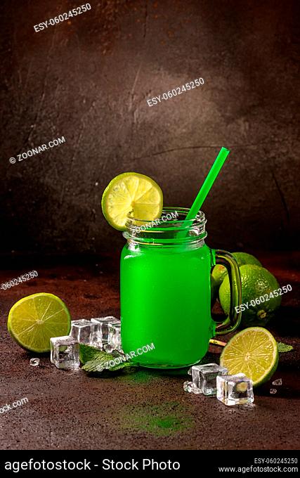 Delicious icy cocktail with fruits on dark grounge background. Healthy colorfull fruit shakes with ice on textured table