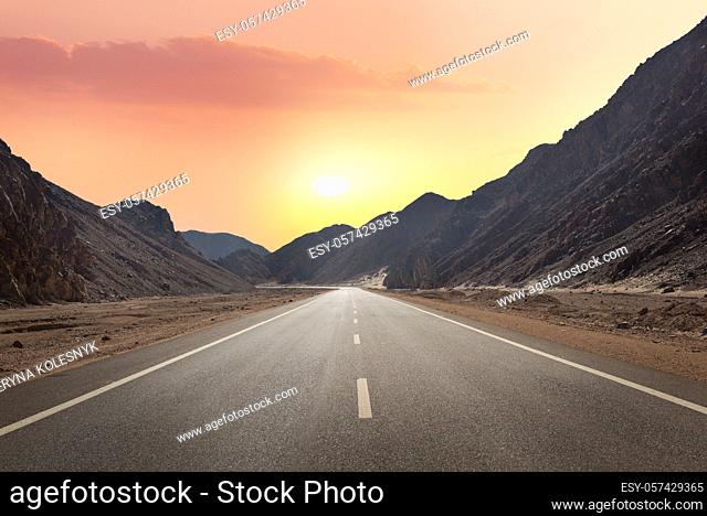 Sunrise over road through mountains in desert of Egypt