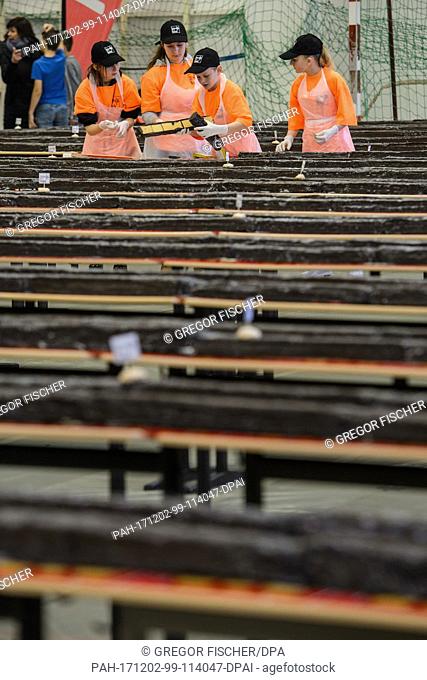 Pupils at the Philipp Reis school cut pieces of the giant ""hedgehog slice"" in a gymnasium for individual sale during an attempt at a world record in Berlin