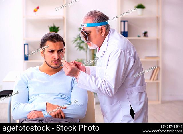 Sick man visiting old doctor otolaryngologist