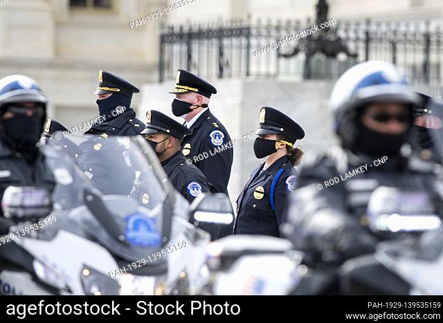 U.S. Capitol Police salute as a hearse carrying an urn with the cremated remains of U.S. Capitol Police officer Brian Sicknick departs the U.S