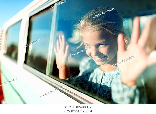 Happy, carefree girl riding in sunny van