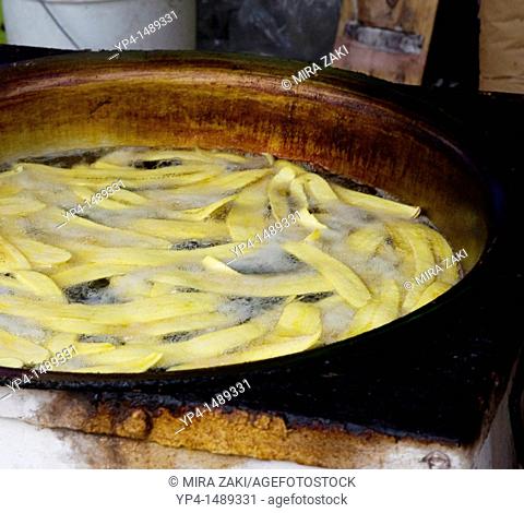 Plaintains frying in a pan at a street vendor's booth in Antigua, Guatemala
