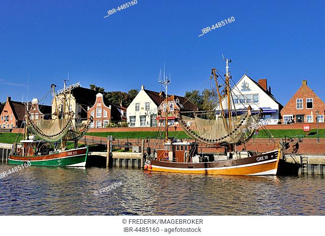 Crab cutters in the harbor, in front of historical buildings, Greetsiel, Lower Saxony, Germany