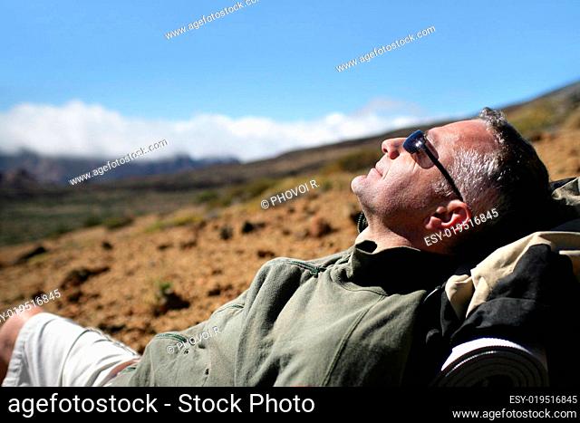 man sitting out on the ground walking with sunglasses Profile