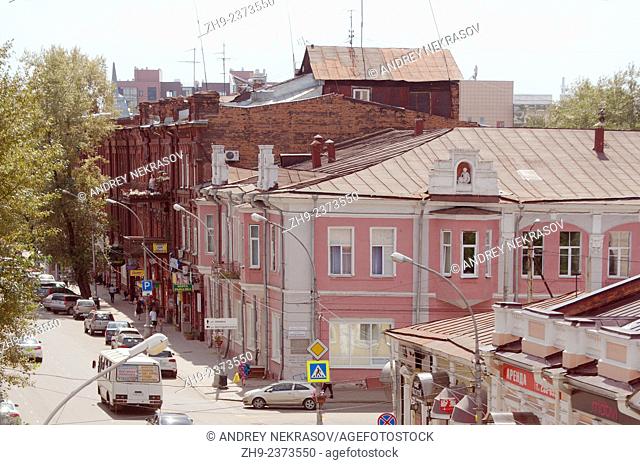Private wooden log house on the roof of a three-storey building in the historic city center. Irkutsk, Siberia, Russian Federation