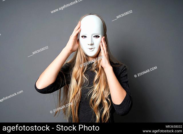 mysterious young woman adjusting her mask with her hands