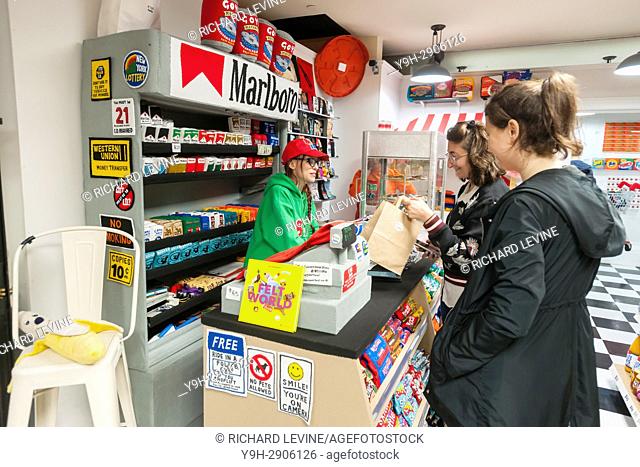 UK artist Lucy Sparrow, left, speaks to customers in her bodega installation, ""8 'till Late"", stocked completely with all-felt facsimiles of products is seen...