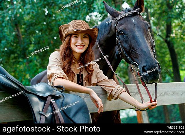 Outdoor happy young woman and a horse