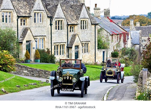 Vintage cars drive through Windrush village on a Veteran Car Club rally day, Gloucestershire, United Kingdom