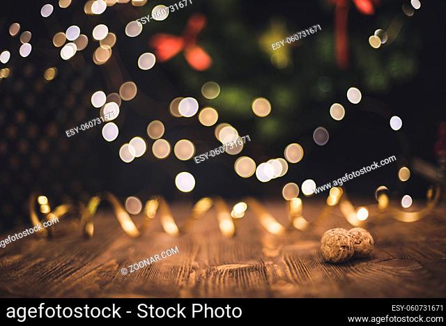 Smooth shady christmas and new year decoration background with round bokeh, golden ribbon and champagne cork