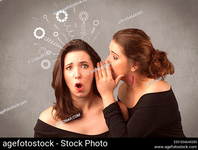 Two girlfriends in elegant black dress sharing secrets with each other concept with drawn rack cog wheels and spiral lines on the wall background