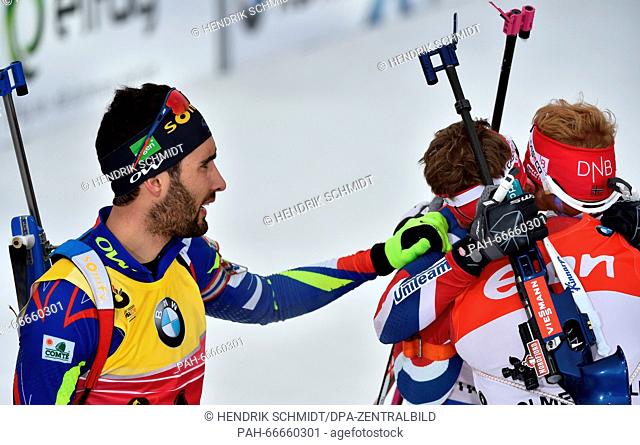 Biathlete Martin Fourcade (L-R) of France and Ole Einar Bjoerndalen of Norway congratulates Biathlete Johannes Thingnes Boe of Norway to win the Men 15km Mass...